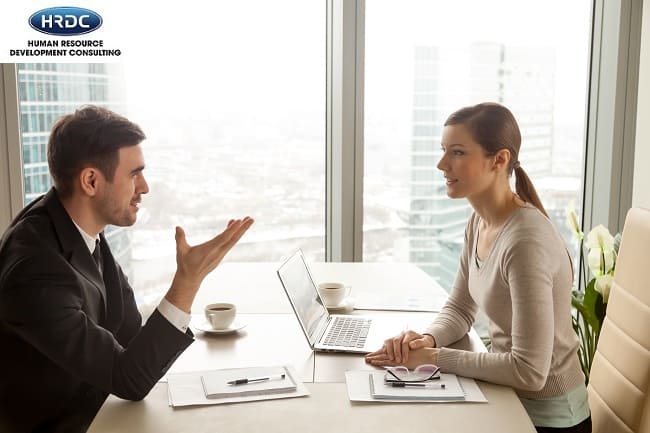 Businessman And Businesswoman Discussing Work At Office Desk Nea